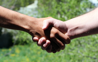 Twee mensen geven elkaar een hand